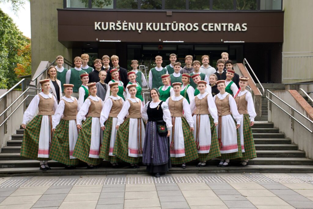 Liaudiškų šokių kolektyvo „Diemedėlis“ šokėjai ir renginio dalyviai po akcijos „Visa Lietuva šoka“ pozuoja prie Kuršėnų kultūros centro.