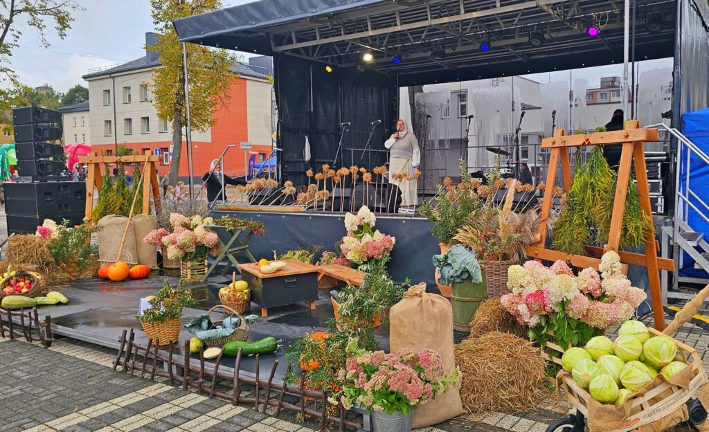 Rudens Jomarko scena Kuršėnuose, papuošta gėlėmis, moliūgais, daržovėmis ir kitomis derliaus gėrybėmis.