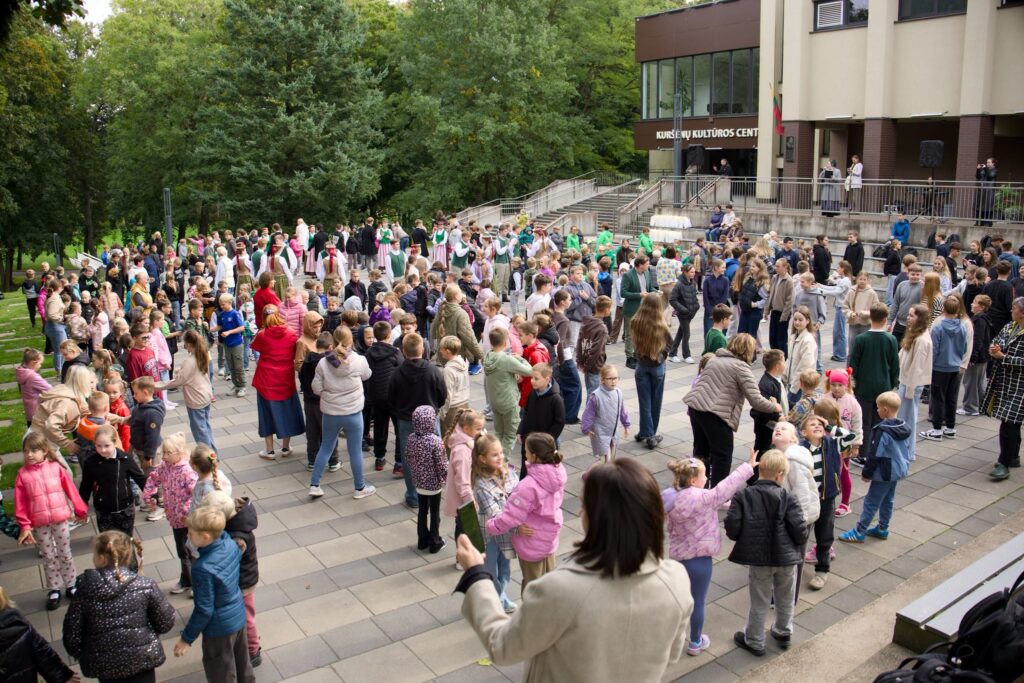 Akcijos „Visa Lietuva šoka“ dalyviai prie Kuršėnų kultūros centro – aikštėje šoka ir bendrauja vaikai, jaunimas bei suaugusieji.