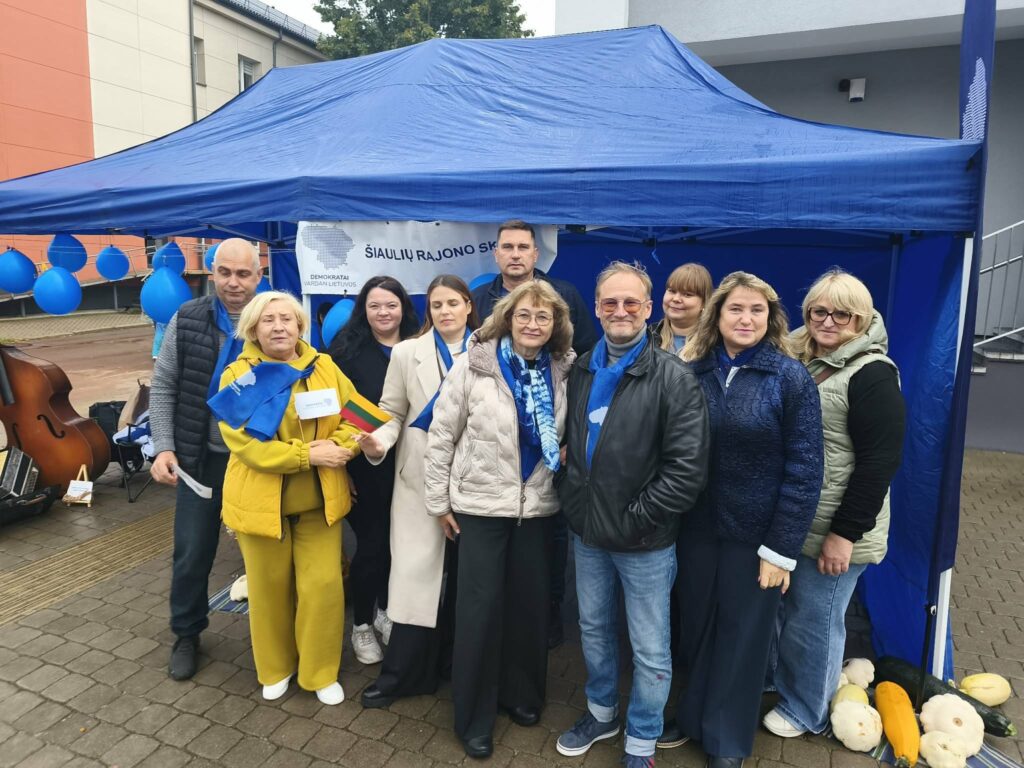 Demokratų sąjungos „Vardan Lietuvos“ Šiaulių rajono skyriaus atstovai ir bendraminčiai fotografuojasi prie mėlynos palapinės Kuršėnų Jomarke.