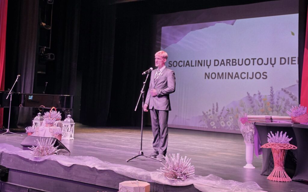 Domas Norkevičius Socialinių darbuotojų dienos šventėje Kuršėnų kultūros centre scenoje skaito savo kūrybos eiles.