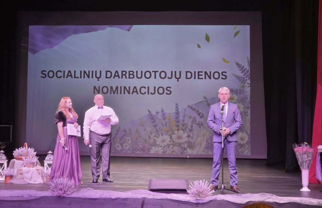 Šiaulių rajono meras Socialinių darbuotojų dienos šventėje Kuršėnų kultūros centre kartu su renginio vedėjais scenoje.