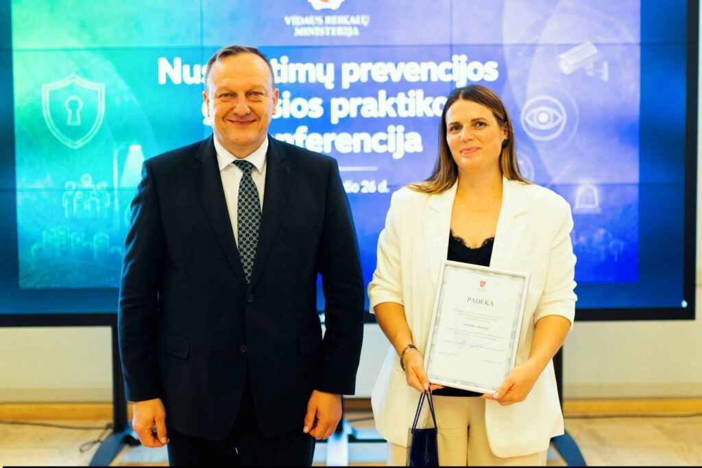 Daugėlių seniūnaitė Sandra Jakė kartu su vidaus reikalų ministru Vladislavu Kondratovičiumi po padėkos ir piniginės premijos įteikimo už gerosios praktikos pavyzdžiu pripažintą priklausomybių prevencijos projektą.