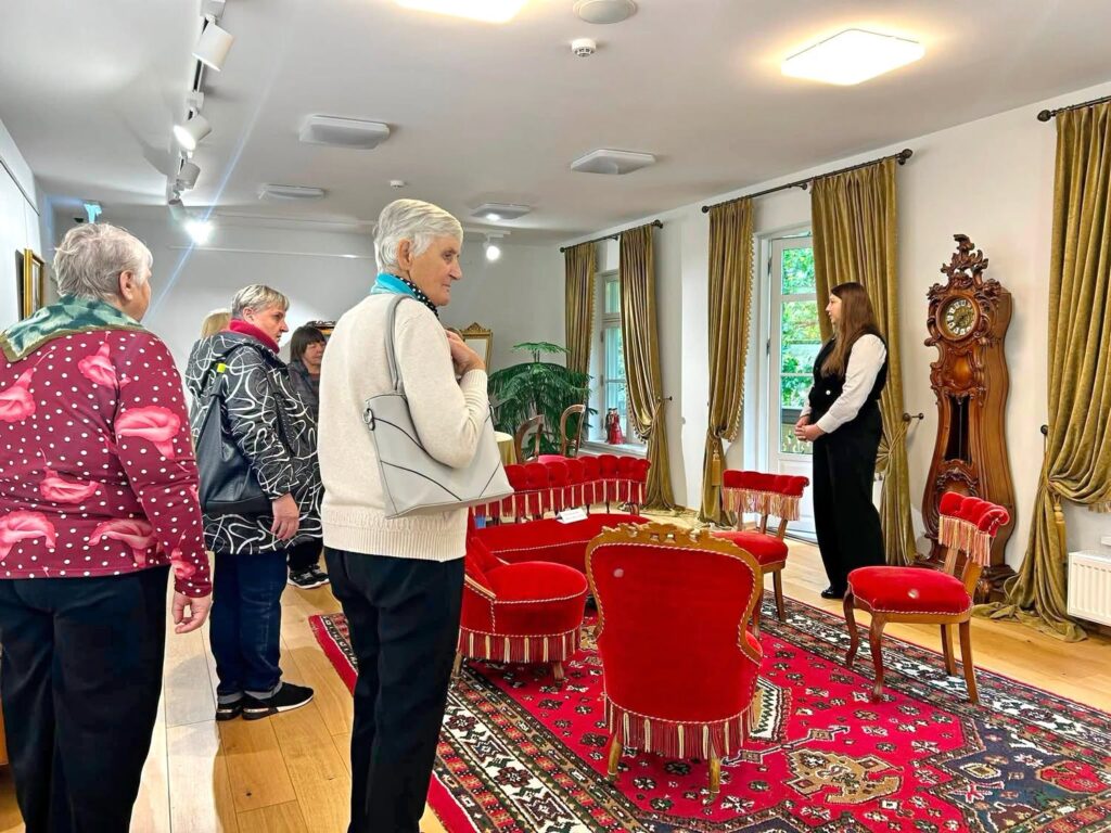 Kuršėnų dvare gidė Simona Sidabrienė ekskursijos „Pasisvečiuokite bajoriškame dvare“ metu pasakoja lankytojams apie bajoriško dvaro gyvenimą ir istoriją.