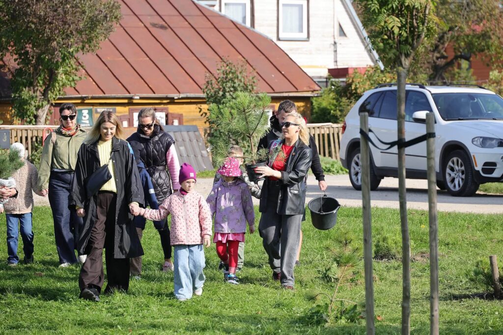 Šiauliuose vykstančios pirmokų medelių sodinimo akcijos dalyviai neša jaunas pušeles į pirmokų sodelį prie Tilžės ir Ežero gatvių sankirtos.