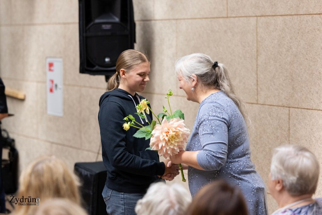 Ugnė Vasiliauskaitė priima gėles per Naisiuose vykusį senjorams skirtą koncertą „Kol širdyje skamba daina“.