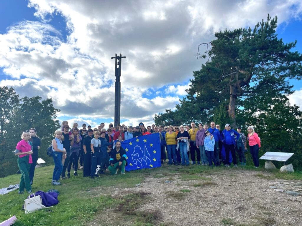 Europos paveldo dienų žygio dalyviai susibūrę Girnikų kalno viršūnėje prie Europos paveldo dienų vėliavos.